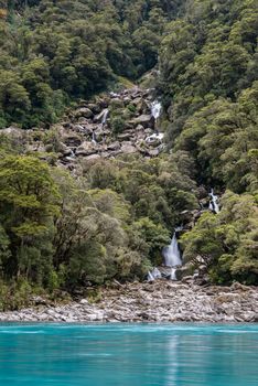 Green jungle, turquoise water and waterfalls of Roaring Billy Falls, Mount Aspiring National Park, New Zealand