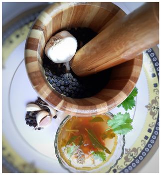 indian traditional food tomato pepper soup in bowl with its spices pepper cumin garlic beautifully kept in white plate