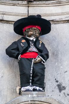 Brussels, Belgium - June 22, 2019: Closeup of iconic and original Manneken Pis statue dressed up in black Spanish clothes.