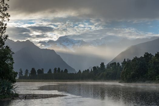 Bright ray of morning sun over the Lake Matheson, New Zealand