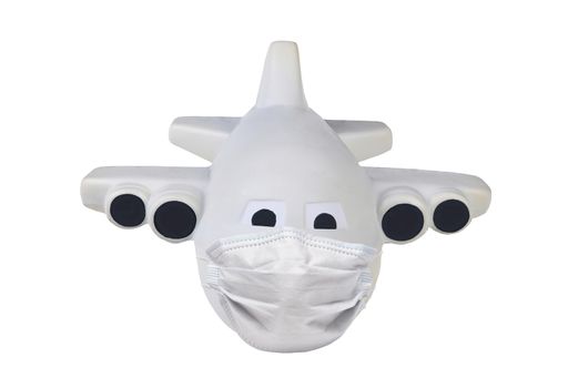 Covid-19 and travel restrictions concept. Toy Airplane with a surgical mask isolated on whte.