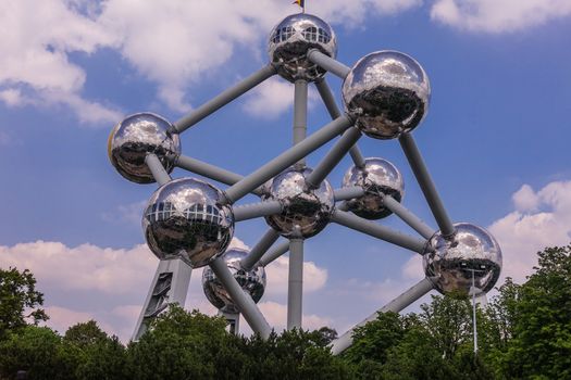 Brussels, Belgium - June 22, 2019: Atomium monument with its silver balls and pipes against blue sky with white cloudscape.