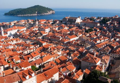 This is a picture of red and orange roofs and distant island behind. Dubrovnik, Croatia.