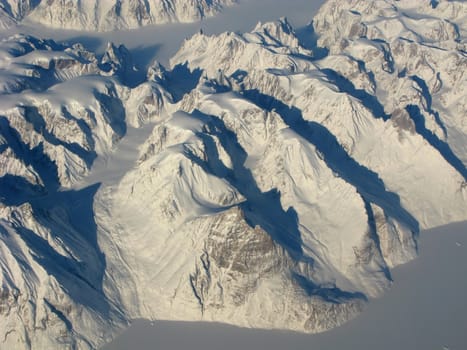 Aerial view of the Greenland with mountains, ocean fields, rocks...