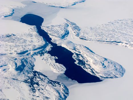 Aerial view of the Canadian lake, surrounded by rocks and snow