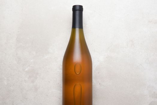 Chardonnay Wine: Top view of a single bottle on a concrete counter top. Bottle is in the middle with copy space on both sides.