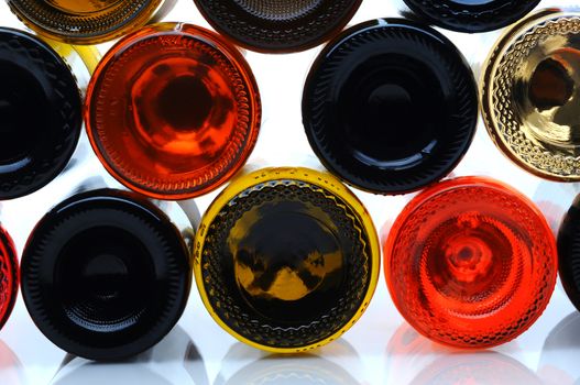 Closeup of several assorted wine bottles laying on their side looking at the bottom side.