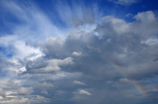 Video shows saturated and colorfull rainbow under beautiful cloud in the sky over lake's surface