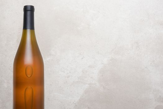 Chardonnay Wine: Top view of a single bottle on a concrete counter top. Bottle is set to the left side with ample copy space.