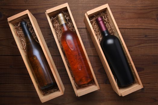 Three Wine Boxes: Blush, Cabernet and Chardonnay wine bottles in individual cases with packing straw. 