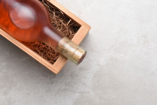 White Zinfandel, Blush Wine: A bottle of Rose wine in a wood box with packing straw. Item is positioned in the upper right corner with copy space.