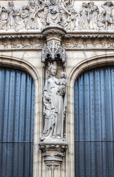Antwerpen, Belgium - June 23, 2019: Closeup of beige stone statue of Madonna and child at the main entrance of Notre Dame, Onze-Lieve-Vrouw, cathedral.