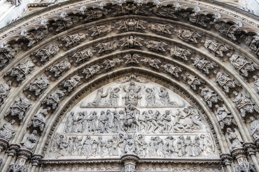 Antwerpen, Belgium - June 23, 2019: Closeup of beige stone bow full of statues above the main entrance of Notre Dame, Onze-Lieve-Vrouw, cathedral.