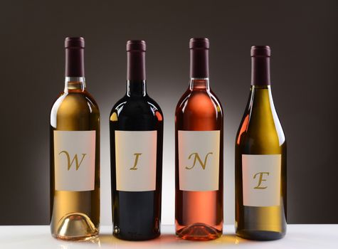 Four Wine Bottles with their labels spelling out the word WINE, on a light to dark gray background. Four different wines including: Cabernet Sauvignon, Chardonnay, Sauvignon Blanc, and White Zinfandel.