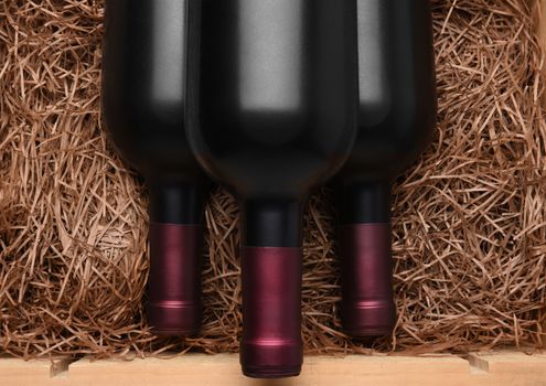Three Cabernet Bottles:  Three Bottles of red wine in a wood case with packing straw.