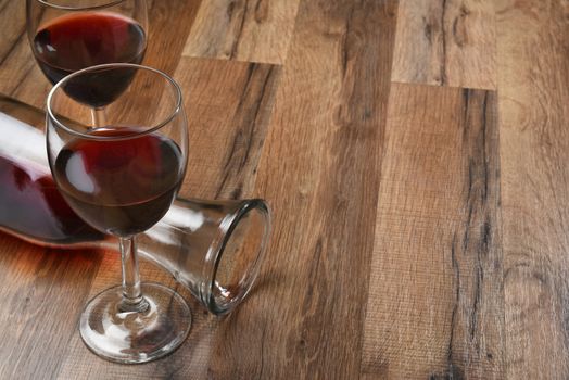 Top view of a carafe and two wine glasses on a wood table with copy space.