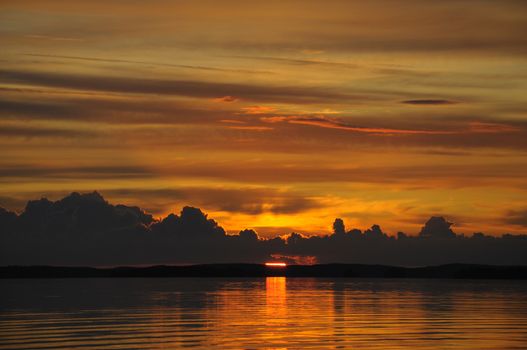 The final stage of a cloudy sunset above the huge lake in Karelia region. The picture is colorful and relaxing.