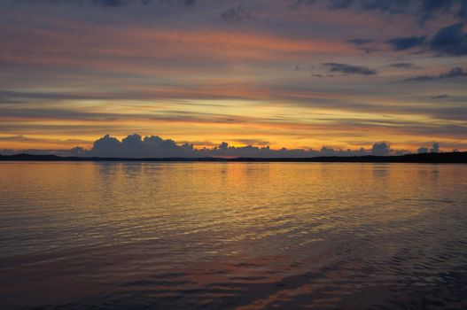 The final stage of a cloudy sunset above the huge lake in Karelia region. The picture is colorful and relaxing.