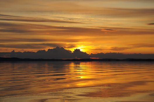 The final stage of a cloudy sunset above the huge lake in Karelia region. The picture is colorful and relaxing.