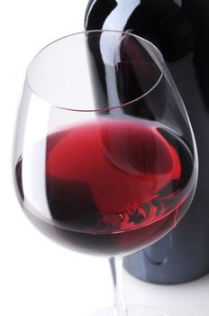 Close up of a Red Wine Bottle with wineglass in front, vertical format over white background