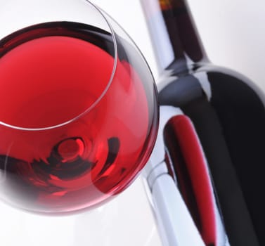 Red Wineglass with Reflection in Bottle laying on its side