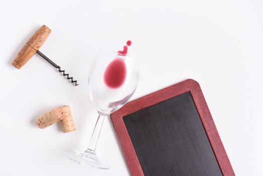 Blank Wine Menu: Chalkboard with wine glass, corkscrew, corks, and wine spill on white with copy space.