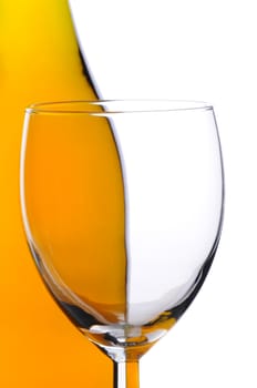 Empty wineglass in front of a bottle of chardonnay wine, close up isolated over white background, vertical composition.