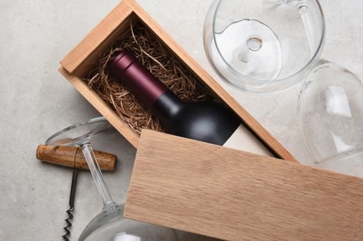 Red Wine Box: A single bottle of Cabernet in a wood box partially covered by its lid with empty glasses and a corkscrew