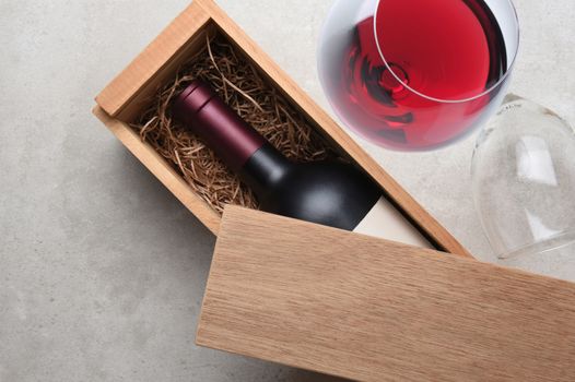 Cabernet Wine Box: A single bottle of red wine in a wood box partially covered by its lid. An Empty glass on its side and one wineglass partially filled.