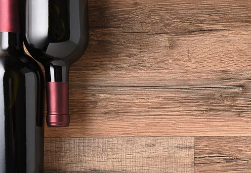 Top view of two wine bottles on a rustic wood table with copy space.