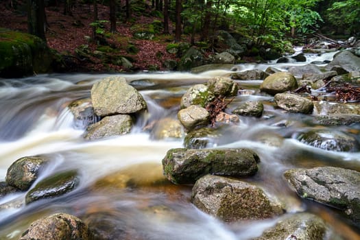 Rocks and boulders in the mountain stream in the forest in the Giant Mountains in Poland