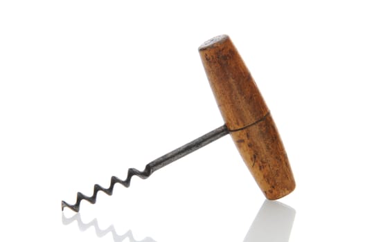 Closeup of an antique wooden handled corkscrew over a white background with reflection.