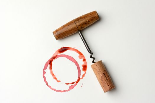 Wine stains cork and corkscrew on paper. Horizontal format. The stains are from wine bottle bottoms and drips.