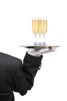 Butler in Tuxedo seen from behind with three champagne glasses on serving ray held at shoulder height vertical format over white