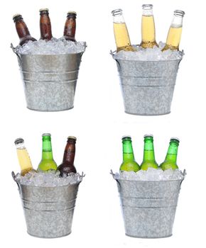 Four buckets holding three each of different beer bottles in ice. The bottles are covered with condensation and isolated on white.