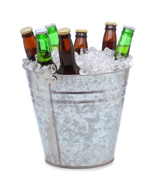 Assorted beer bottles in a bucket of ice isolated on a white background. Vertical format with reflection.