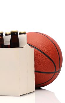 Close up of a six pack of beer bottles with a basketball on a white background.