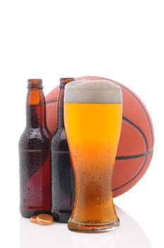 Two open beer bottles and a glass with a basketball on a white background.  Vertical format from a low angle with reflection. 