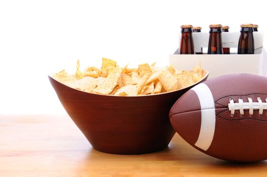 Chips, football and Six Pack of Beer on a table with a white background. Horizontal format.