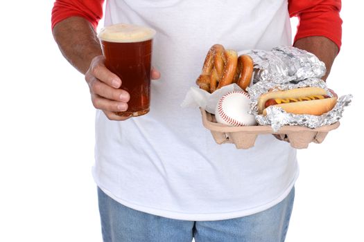Closeup of a sports fan carrying a tray of food and souvenirs in one hand and a beer in the other. Food tray holds hot dogs and pretzels and a souvenir baseball.