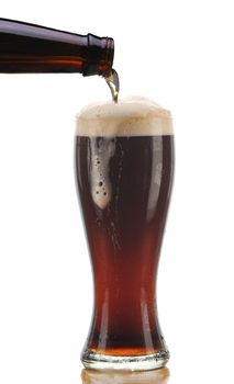Glass of Dark Ale Beer being Poured from Bottle with Foam Drip and Reflection isolated on white