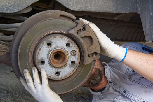 Old and dirty rear dump break of the vehicle for repair. Brakes on a car with removed wheel. Detail image of cars break assembly before repair