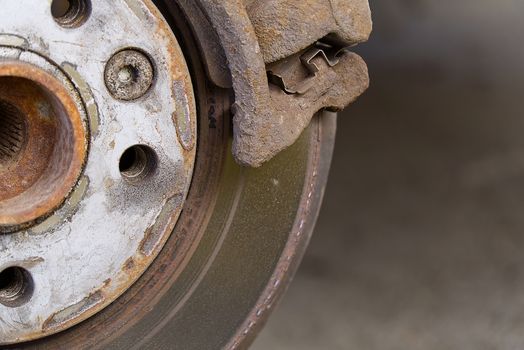 Old and dirty rear dump break of the vehicle for repair. Brakes on a car with removed wheel. Detail image of cars break assembly before repair