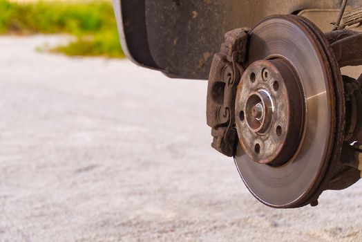 Old and dirty rear dump break of the vehicle for repair. Brakes on a car with removed wheel. Detail image of cars break assembly before repair