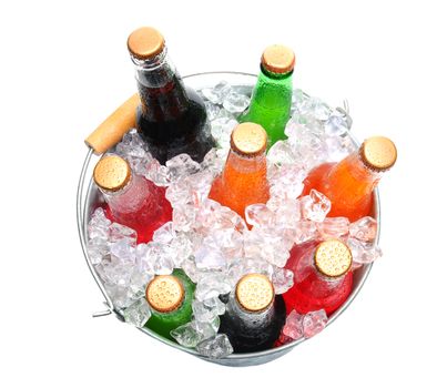 Top view of a bucket full of ice and soda bottles. Isolated over a white background.