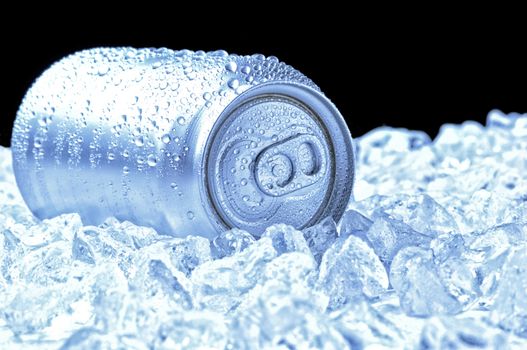 Aluminum Drink Can with water droplets laying in a bed of ice - black background and cool tones