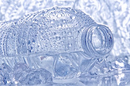 Water bottle laying on its side with droplets and drip coming out of the opening. Intentional cool tones and shallow depth of field.