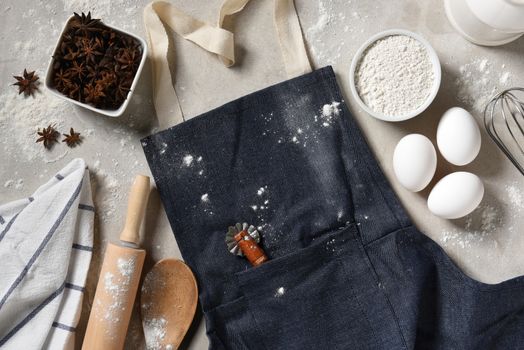 Baking Still Life: A denim apron with eggs, flour and equipment for making holiday cookies and desserts.