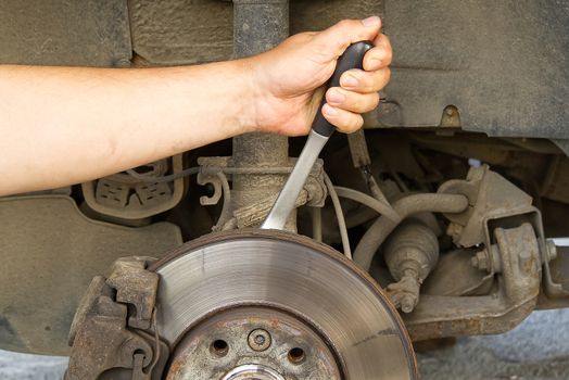 Old and dirty rear dump break of the vehicle for repair. Brakes on a car with removed wheel. Detail image of cars break assembly before repair