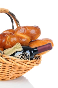 A basket full of bread and a wine bottle over a white background with slight reflection.
